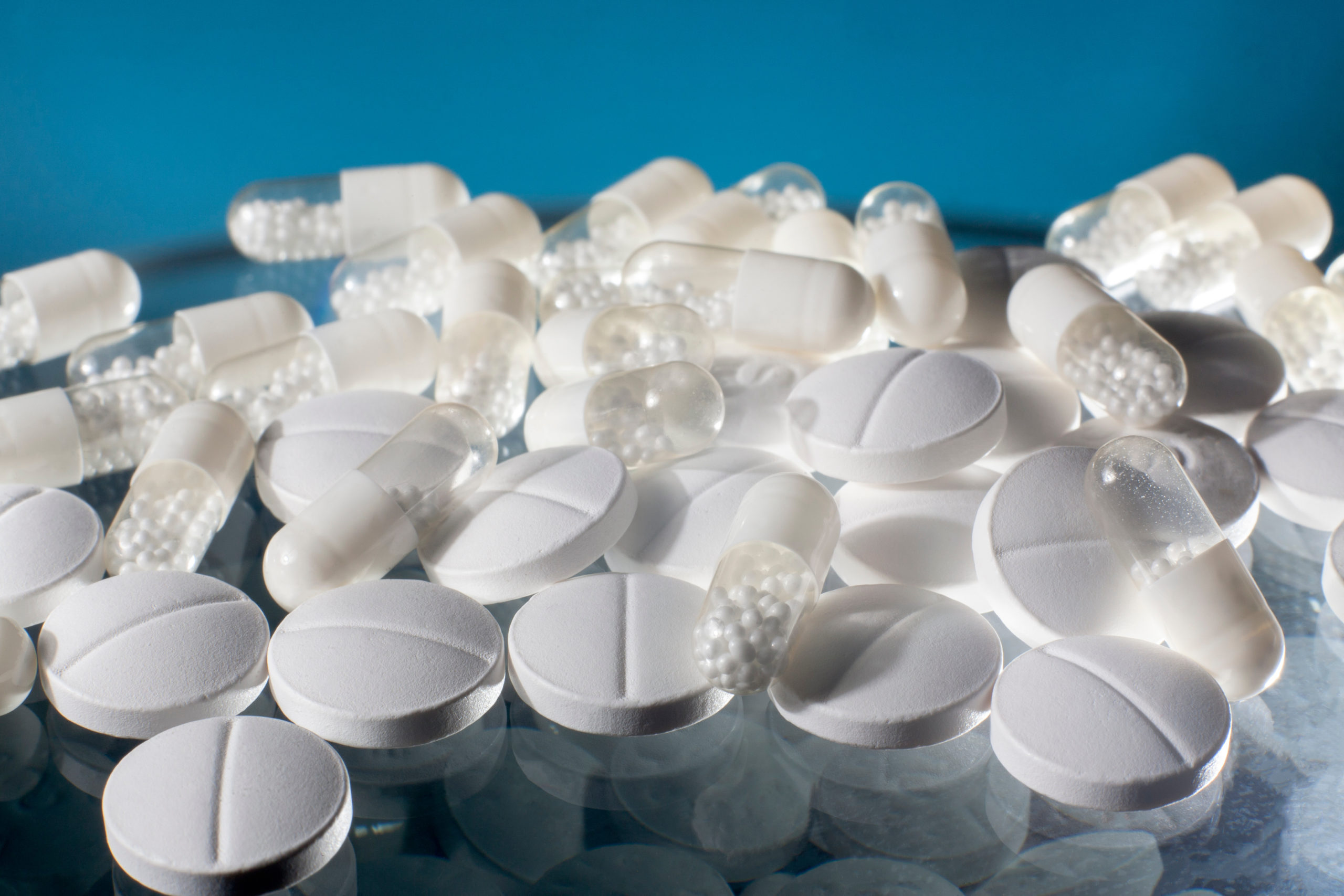 Medicine pills and capsules with blue background