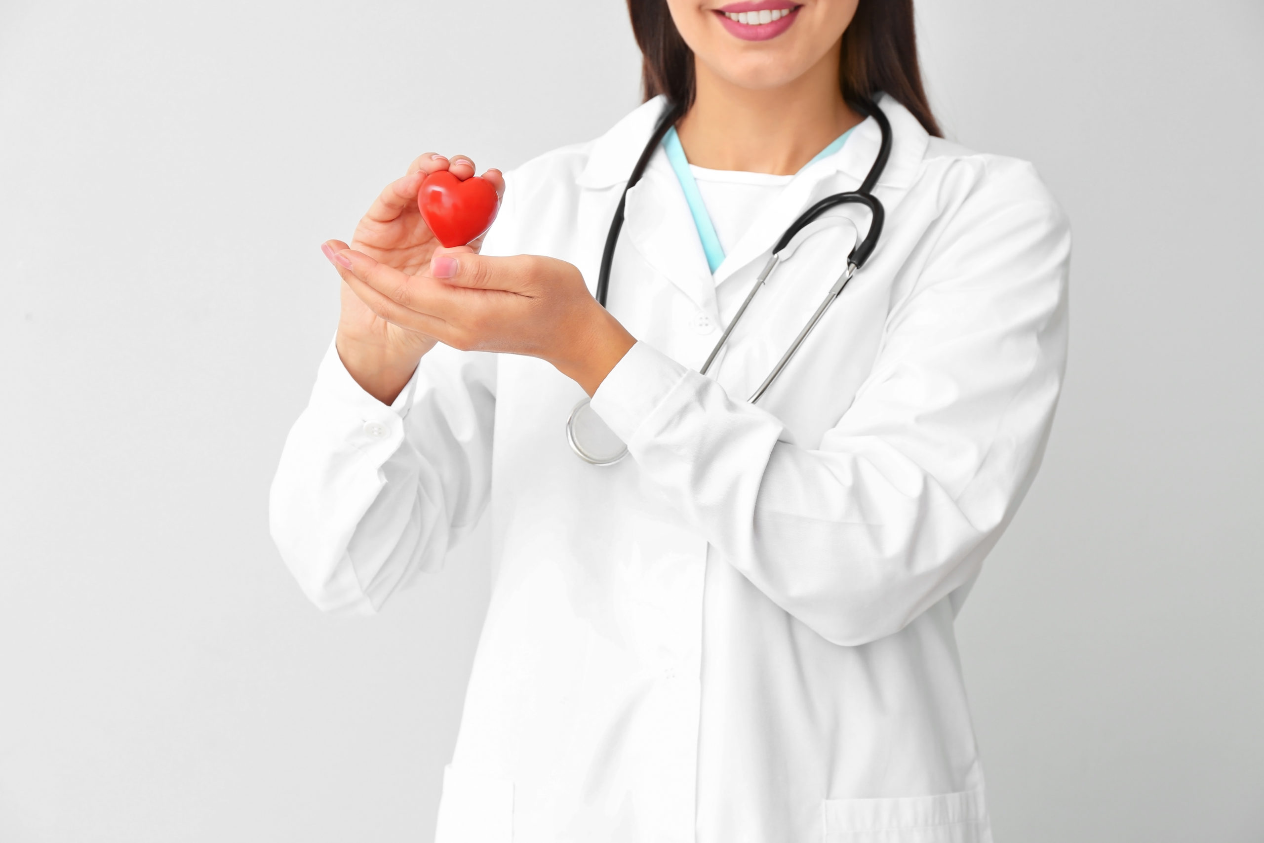 Female cardiologist on light background